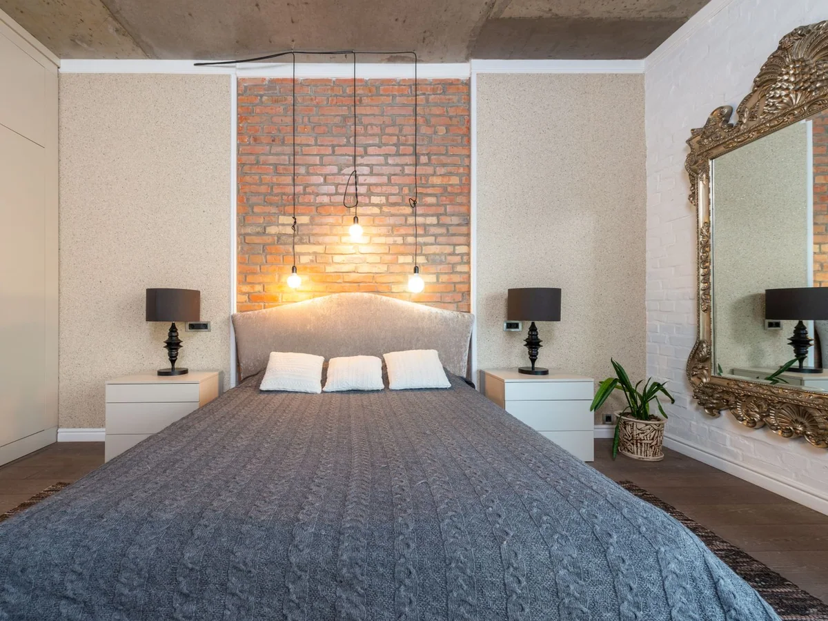 A neatly made bed with breathable cotton sheets and a light blanket in a calm bedroom