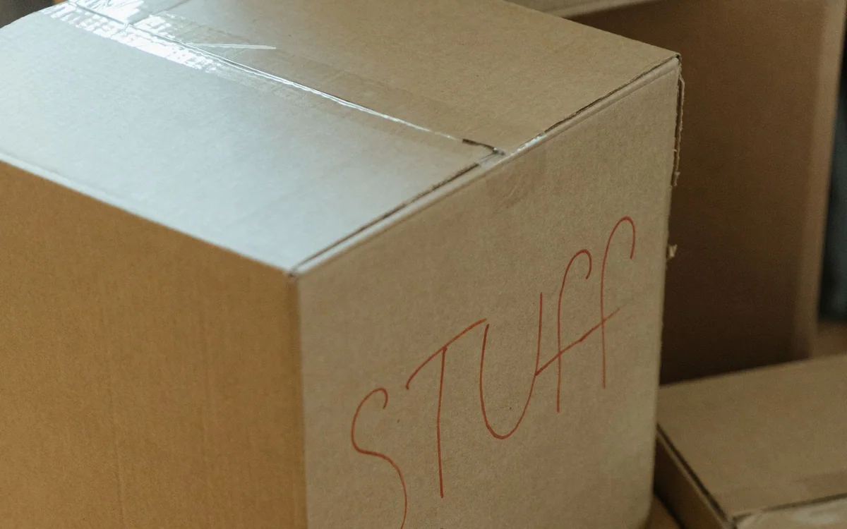 A person labeling and stacking storage bins in a garage