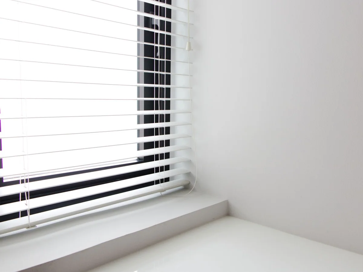 A renter-friendly tension curtain rod holding lightweight curtains in an apartment