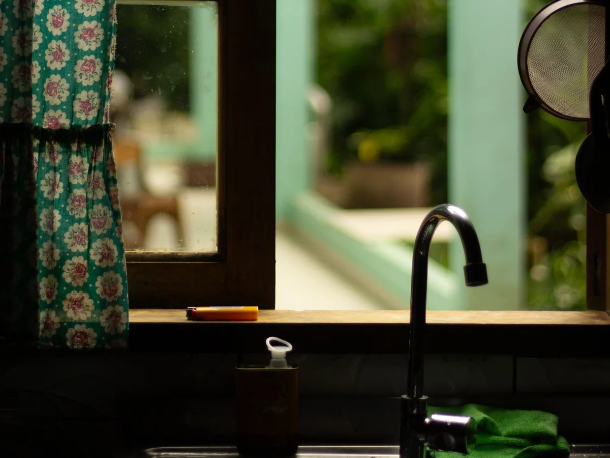 A pull-down kitchen faucet spraying water into a large family sink