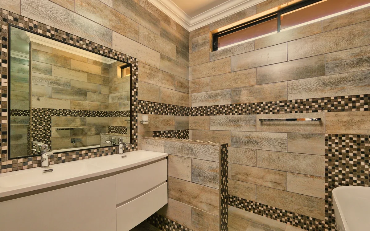 A tension pole shower organizer being adjusted between two tiled walls