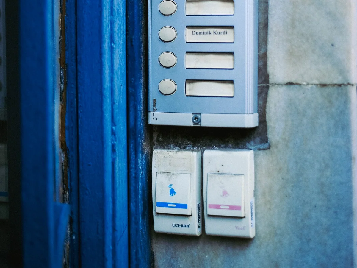 A battery video doorbell beside a rental apartment entry door